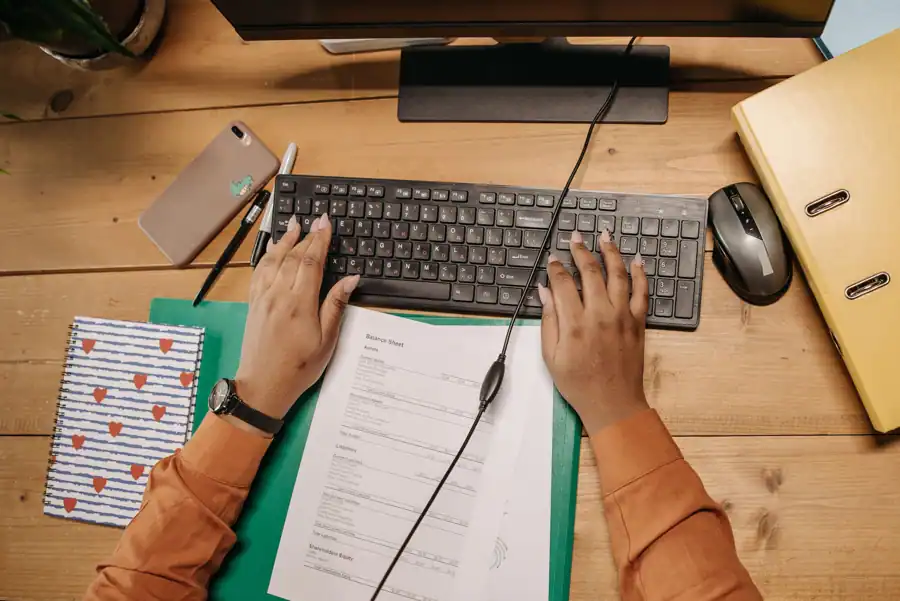 Desk with a job posting on screen and a handwritten skills checklist