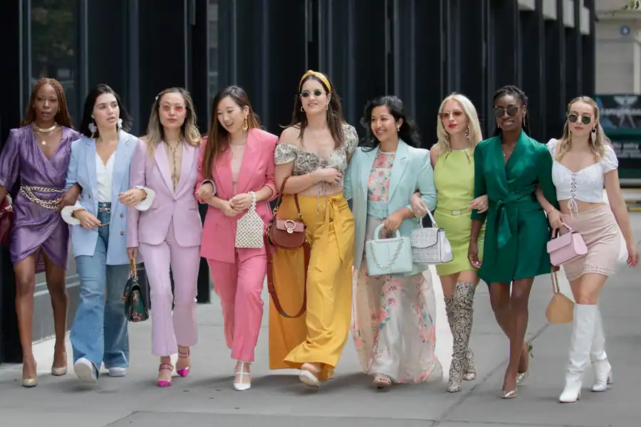 Group of stylish women walking together in vibrant outfits in New York City.